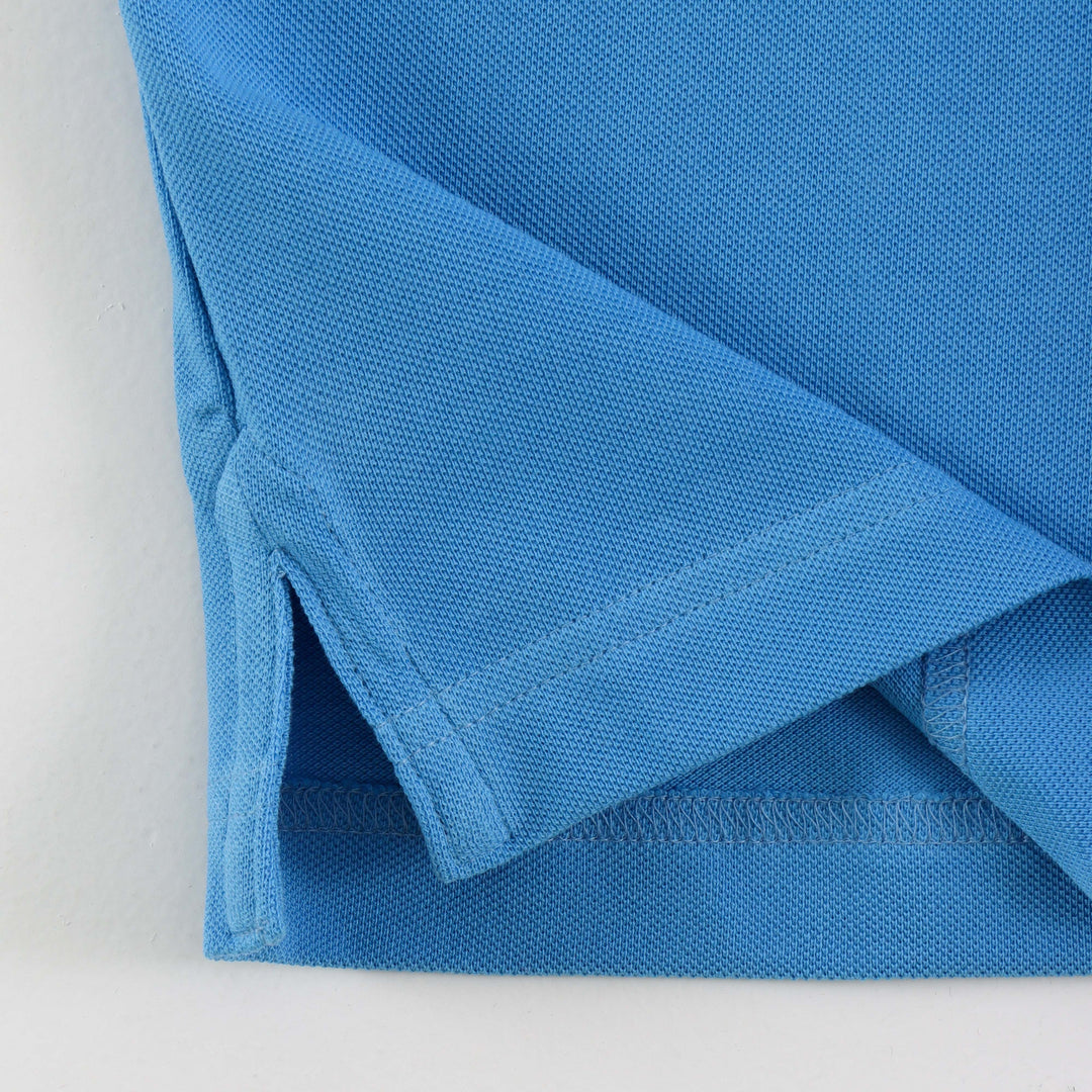 Close-up of Dare Wolf logo on blue polo t-shirt