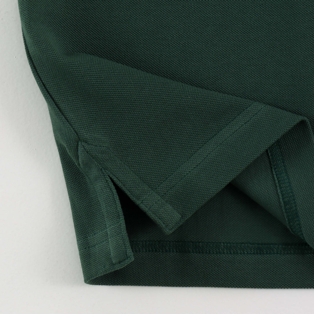 Close-up of Dare Wolf logo on dark green polo t-shirt