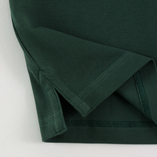 Close-up of Dare Wolf logo on dark green polo t-shirt