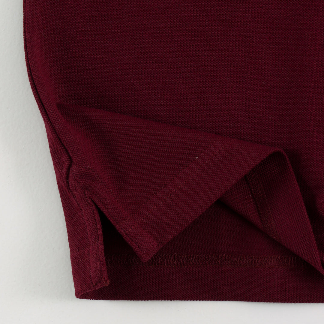 Close-up of Dare Wolf logo on maroon polo t-shirt