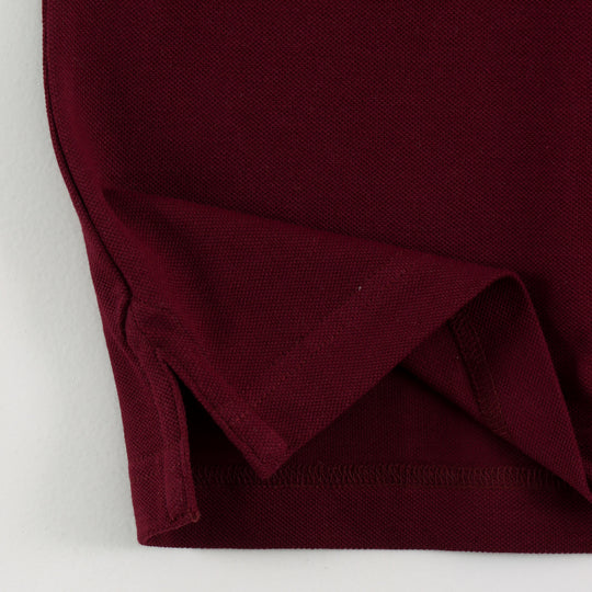 Close-up of Dare Wolf logo on maroon polo t-shirt