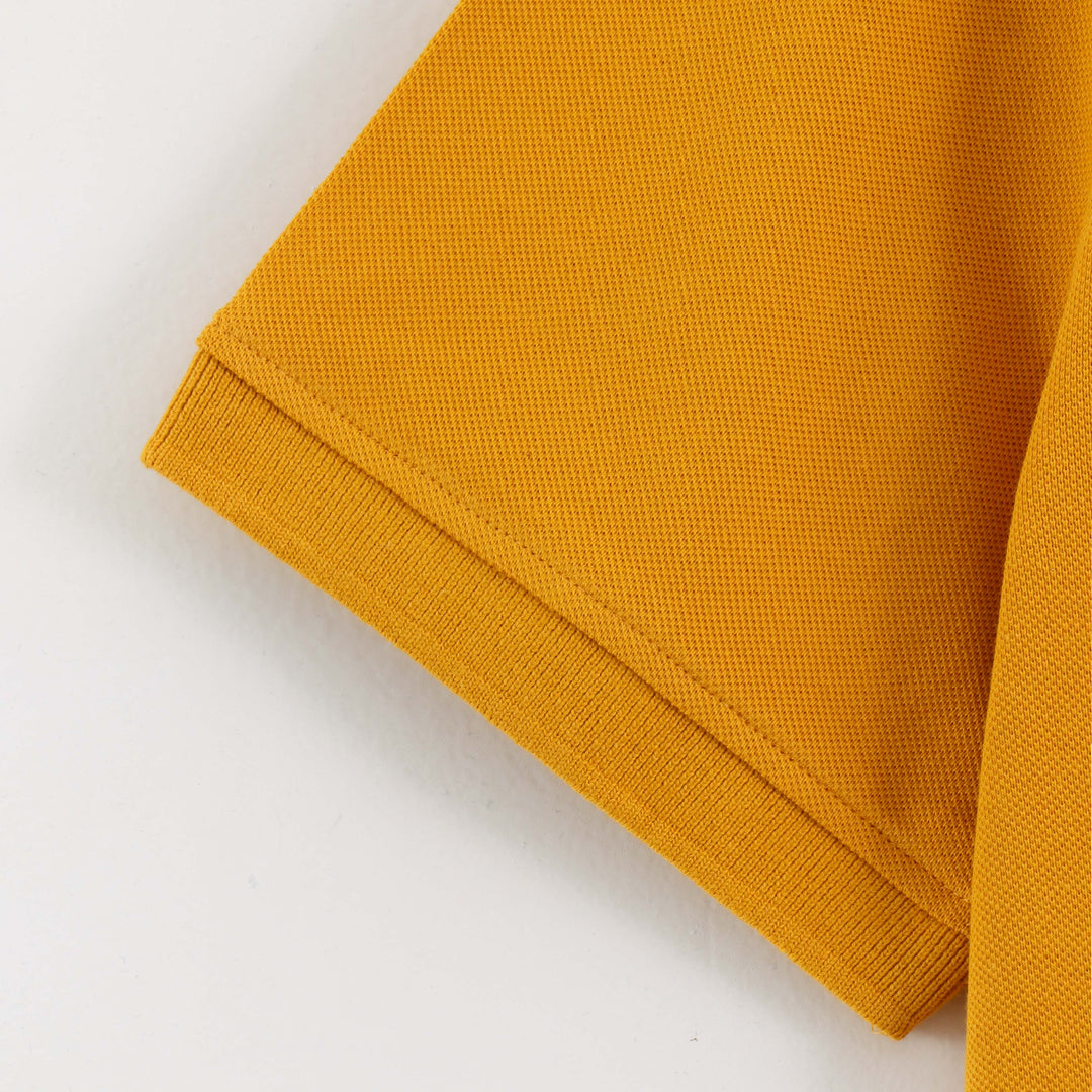 Close-up detail of Dare Wolf yellow polo t-shirt sleeve