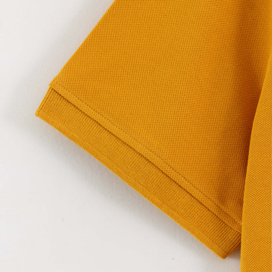 Close-up detail of Dare Wolf yellow polo t-shirt sleeve