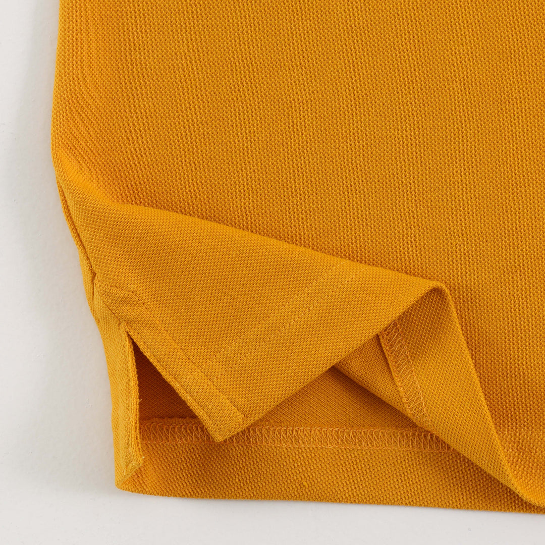 Close-up of Dare Wolf logo on yellow polo t-shirt