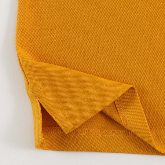 Close-up of Dare Wolf logo on yellow polo t-shirt